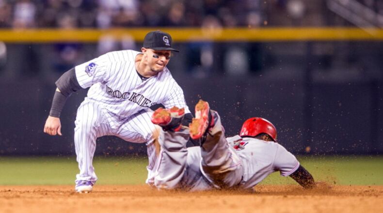 DENVER, CO - AUGUST 30: Brandon Phillips #4 of the Cincinnati Reds slides in safely to second base on a wild pitch under a tag attempt by Troy Tulowitzki #2 of the Colorado Rockies during the ninth inning of a game at Coors Field on August 30, 2013 in Denver, Colorado. The Rockies beat the Reds 9-6. (Photo by Dustin Bradford/Getty Images)