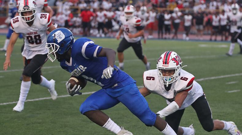 Dunbar's Darian Leslie avoids a tackle by Wayne's Joshua Williams during a game in 2021. BILL LACKEY/STAFF