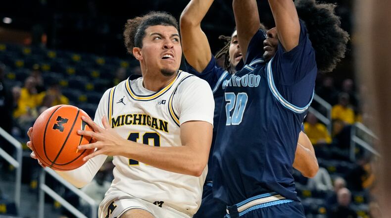 Michigan guard George Washington III (40) drives under the basket as Northwood forward Quinton Steele II (20) defends during the first half of an NCAA college exhibition basketball game, Friday, Nov. 3, 2023, in Ann Arbor, Mich. (AP Photo/Carlos Osorio)