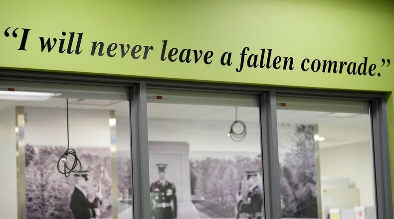 A quote is seen on a wall outside of a Defense POW/MIA Accounting Agency lab at Offutt Air Force Base, Monday, May 20, 2024, in Bellevue, Neb. Generations of American families have grown up without ever knowing exactly what happened to their loved ones who served in the military. But a lab tucked away above the bowling alley on Offutt Air Force Base in the Omaha suburbs and a sister lab in Hawaii that are part of the federal DPAA are steadily answering those lingering questions and offering about 200 families a year the chance to honor their relatives with a proper burial. (AP Photo/Charlie Neibergall)
