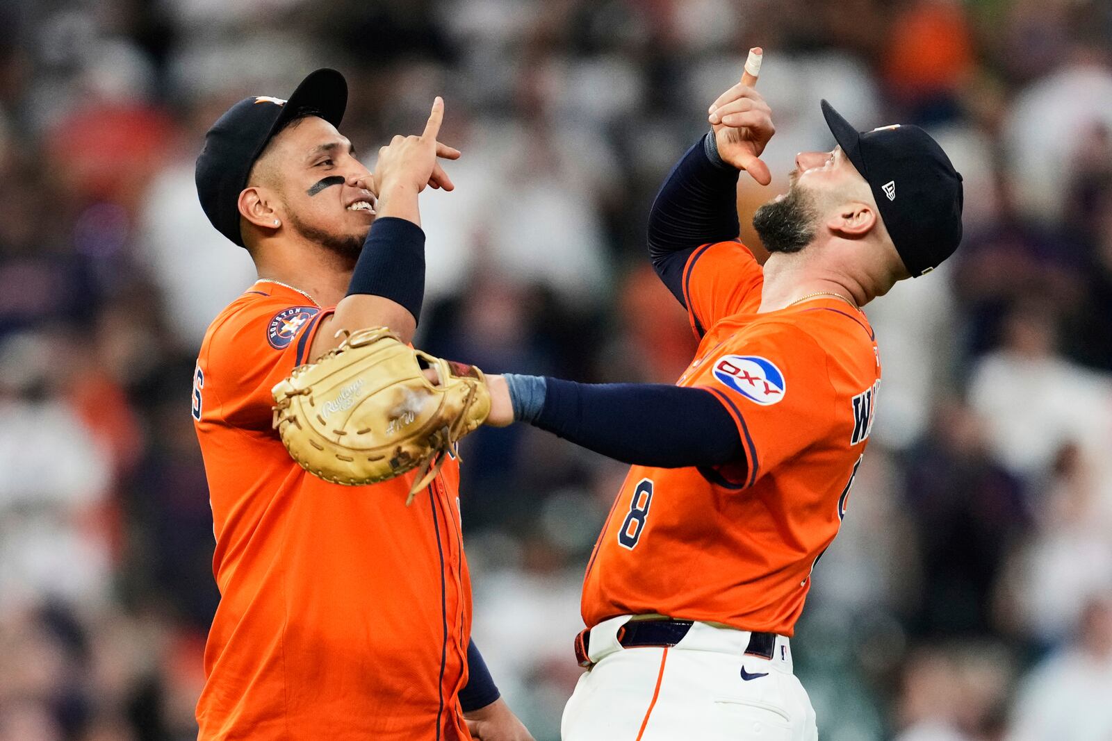 Houston Astros third baseman Isaac Paredes, left, and first baseman Christian Walker (8) celebrate after winning a baseball game against the Cincinnati Reds in Houston, Friday, May 9, 2025. (AP Photo/Ashley Landis)