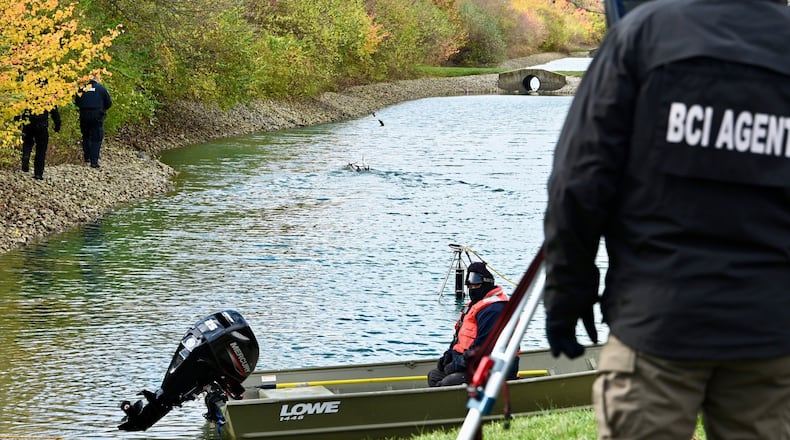 Rescue workers searched a pond Thursday at a West Chester Twp. apartment complex for a missing 7-year-old boy with a boat drone. MICHAEL D. PITMAN/STAFF