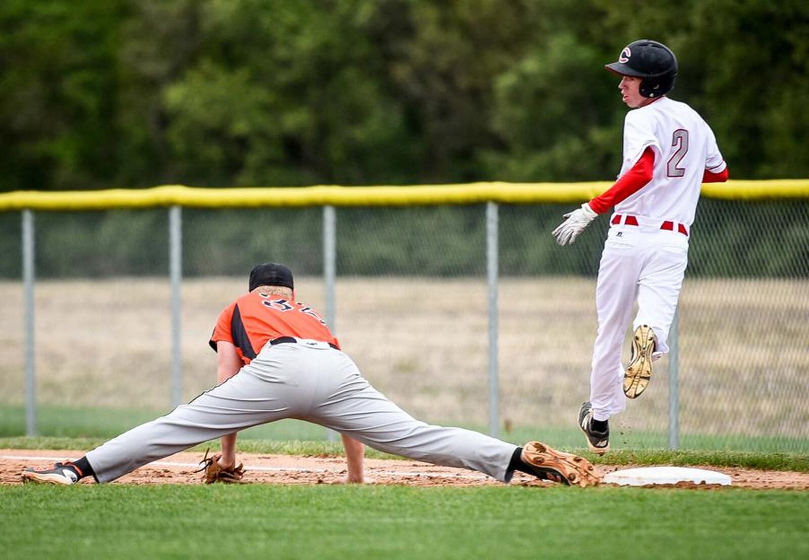 Carlisle’s Caleb Stewart is safe at first base, despite the efforts of Waynesville first baseman Tommy Isaacs, during Monday’s game at Sam Franks Field in Carlisle. NICK GRAHAM/STAFF