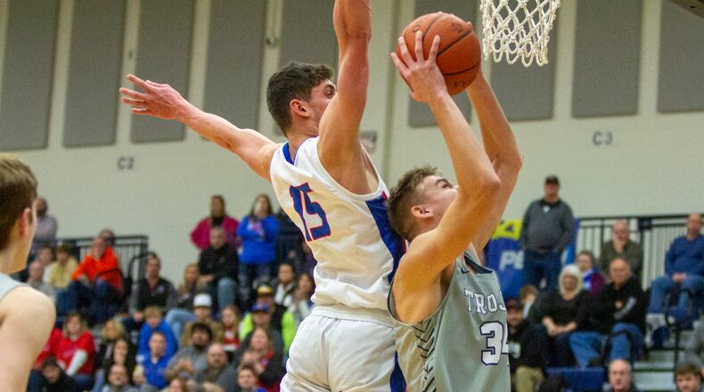 Botkins' Elijah Stewart scores inside against Tri-Village's Layne Sarver at Flyin' To The Hoop at Trent Arena on Sunday. Stewart scored 13 points in his first start. Jeff Gilbert/CONTRIBUTED