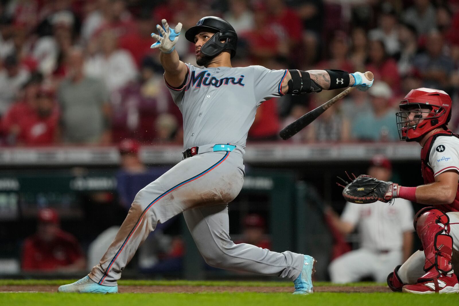 Miami Marlins' Agustín Ramírez hits a solo home run as Cincinnati Reds catcher Tyler Stephenson, right, looks on during the seventh inning of a baseball game in Cincinnati, Monday, July 7, 2025. (AP Photo/Carolyn Kaster)