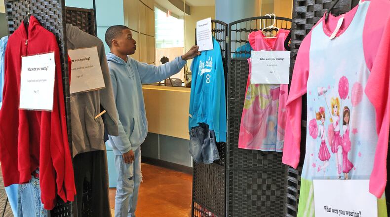 Harrison Moore, a student at Clark State reads one of the information tags on the "What Were You Wearing?" sexual assault exhibit on display in the Sara T. Landess Technology and Learning Center Friday. BILL LACKEY/STAFF