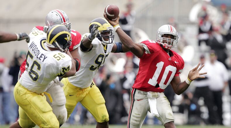 COLUMBUS, OH - NOVEMBER 20:  Quarterback Troy Smith #10 of the Ohio State Buckeyes throws under pressure from defensive end LaMarr Woodley #56 and defensive tackle Marques Walton #95 of the Michigan Wolverines on November 20, 2004 at Ohio Stadium in Columbus, Ohio.  Ohio State upset Michigan 37-21.  (Photo by Brian Bahr/Getty Images)