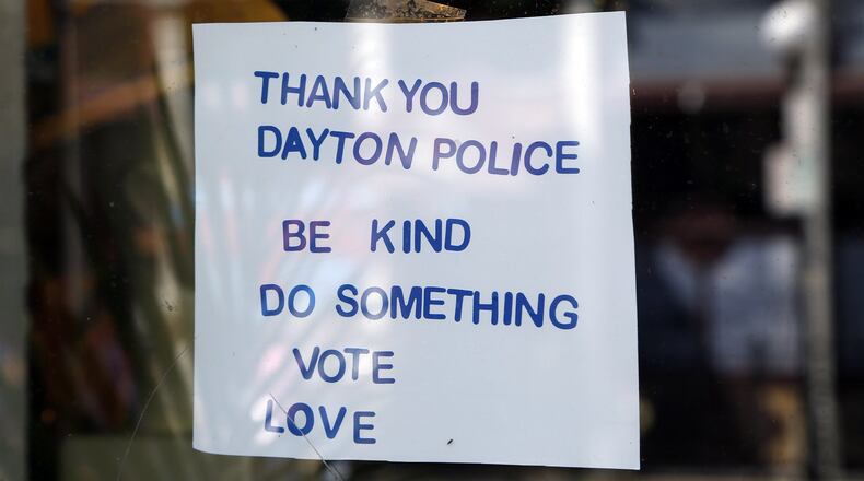 Signs supporting the Dayton Police Department can be found throughout the Oregon District, including this window sign at Feathers. TY GREENLEES / STAFF Signs supporting the Dayton Police Department can be found throughout the Oregon District, including this chalkboard sign at Heart Mercantile. TY GREENLEES / STAFF