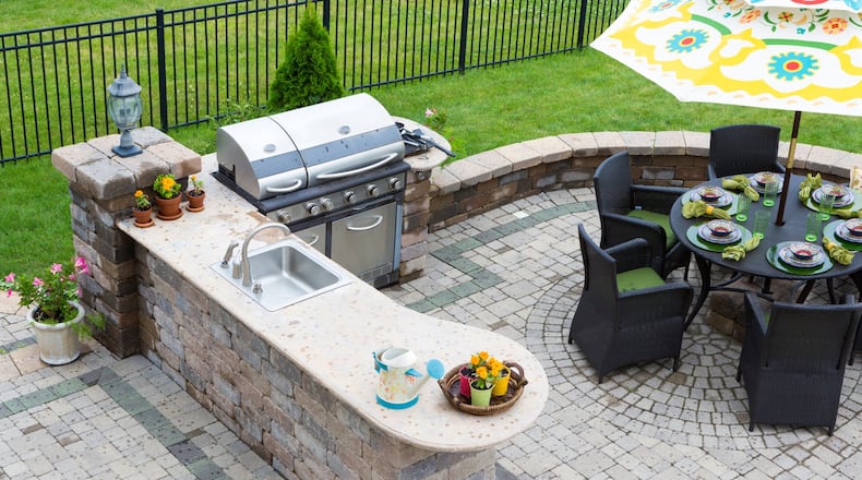 Grills, sinks, refrigerators and stone countertops are popular outdoor kitchen features. (Dreamstime)