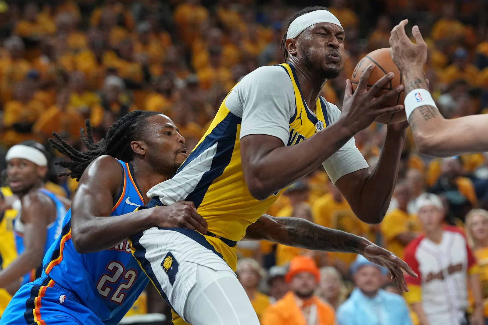 Indiana Pacers center Myles Turner is pressured by Oklahoma City Thunder guard Cason Wallace (22) during the first half of Game 4 of the NBA Finals basketball series, Friday, June 13, 2025, in Indianapolis. (AP Photo/Michael Conroy)