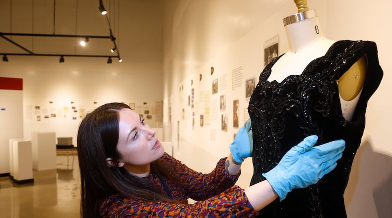 Hadley Drodge, assistant curator at the National Afro-American Museum & Cultural Center in Wilberforce, fits a dress that belonged to civil rights leader Anna Arnold Hedgeman for an anniversary exhibit, Color Outside the Lines: Celebrating Thirty Years at NAAMCC. LISA POWELL / STAFF