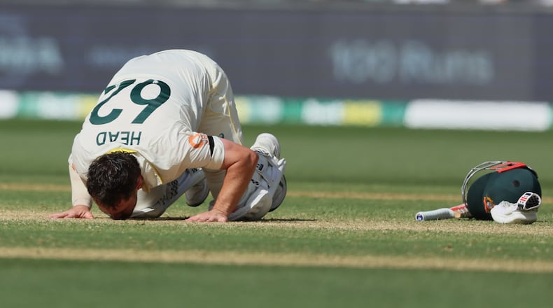 Australia's Travis Head kisses the pitch after scoring a century during play on day three of the third Ashes cricket test between England and Australia in Adelaide, Australia, Friday, Dec. 19, 2025. (AP Photo/James Elsby)