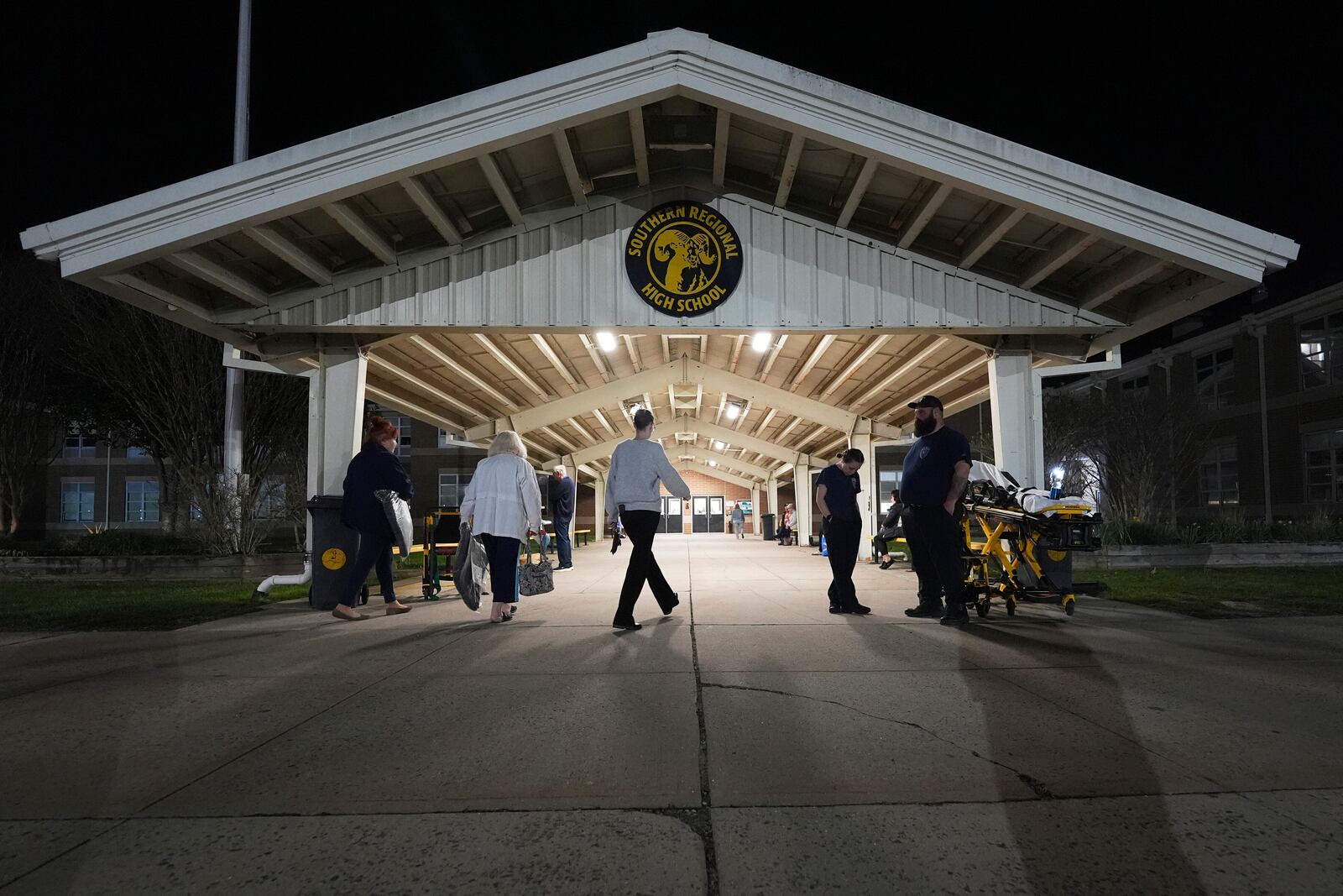 People head into an evacuation shelter at Southern Regional High School from wildfires on Tuesday, April 22, 2025, near Stafford Township, N.J. (AP Photo/Chris Szagola)