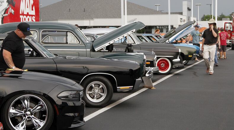 An owner wipes down his Camaro and the rain starts to sprinkle on a row of black cars at the Voss Hoss Cruise-in. © 2018 Photograph by Skip Peterson