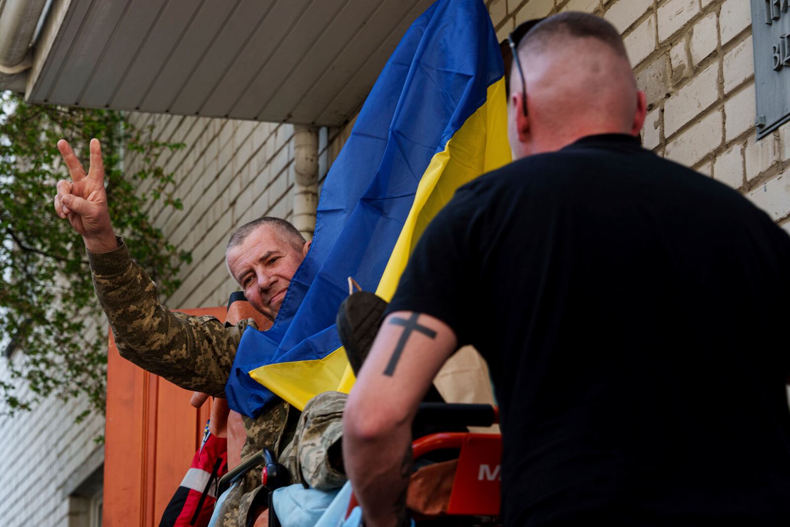 An injured Ukrainian soldier makes a victory sign after returning from captivity in a POW exchange in Ukraine, on Saturday, April. 19, 2025. (AP Photo/Evgeniy Maloletka)