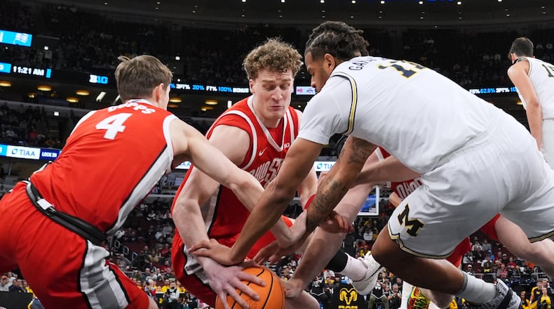 Ohio State center Christoph Tilly, center, battles for a loose ball against guard Gabe Cupps, left, and Michigan guard Roddy Gayle Jr. during the first half of an NCAA college basketball game in the quarterfinals of the Big 10 Conference tournament, Friday, March 13, 2026, in Chicago. (AP Photo/Nam Y. Huh)