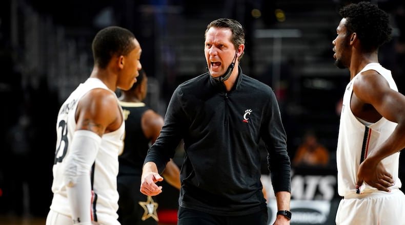 Cincinnati head coach John Brannen, center, instructs the team during a timeout in the first half of an NCAA college basketball game against Vanderbilt, Thursday, March 4, 2021, in Cincinnati. Kareem Elgazzar/The Cincinnati Enquirer via AP)