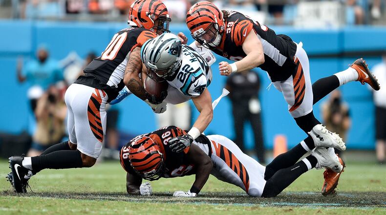 CHARLOTTE, NC - SEPTEMBER 23: Jessie Bates #30, Shawn Williams #36 and Nick Vigil #59 of the Cincinnati Bengals tackle Christian McCaffrey #22 of the Carolina Panthers during their game at Bank of America Stadium on September 23, 2018 in Charlotte, North Carolina. (Photo by Grant Halverson/Getty Images)