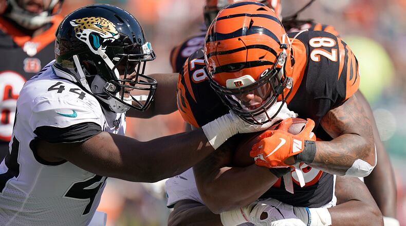 CINCINNATI, OHIO - OCTOBER 20: Joe Mixon #28 of the Cincinnati Bengals is tackled by Myles Jack #44 of the Jacksonville Jaguars during the NFL football game at Paul Brown Stadium on October 20, 2019 in Cincinnati, Ohio. (Photo by Bryan Woolston/Getty Images)