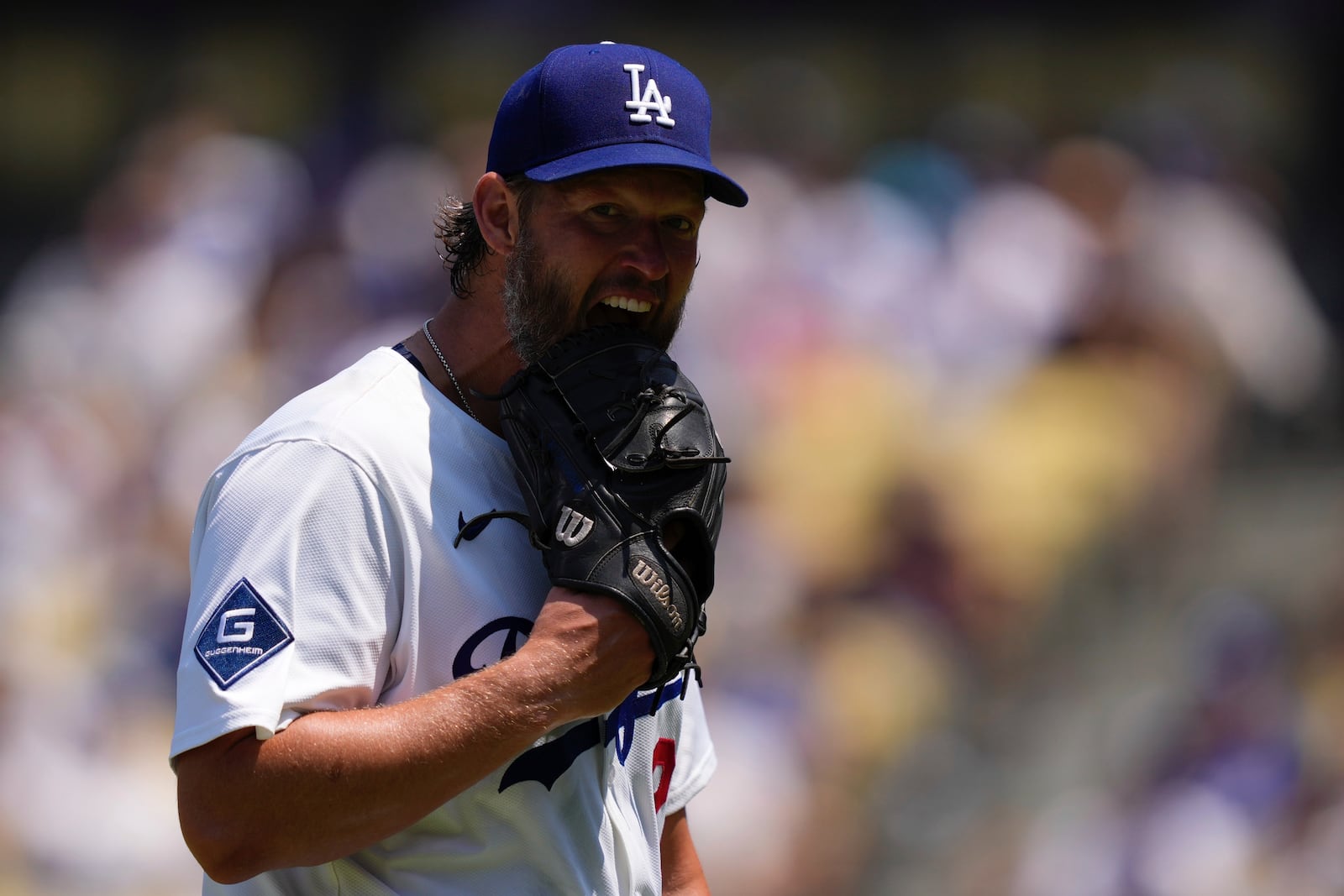 Los Angeles Dodgers starting pitcher Clayton Kershaw bites his glove after being taken out of the game I'm the fifth during inning of a baseball game against the Milwaukee Brewers, Sunday, July 20, 2025, in Los Angeles. (AP Photo/Mark J. Terrill)