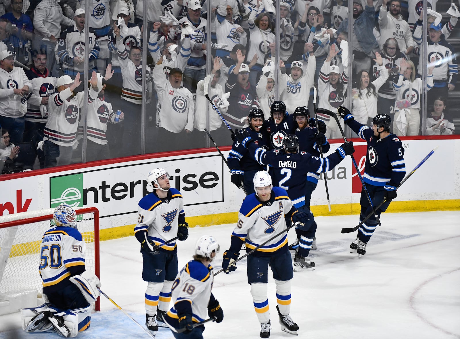 Winnipeg Jets' Mark Scheifele (55) celebrates his goal on St. Louis Blues goaltender Jordan Binnington (50) with teammates during the first period of an NHL hockey playoff game in Winnipeg, Manitoba, Monday April 21, 2025. (Fred Greenslade/The Canadian Press via AP)