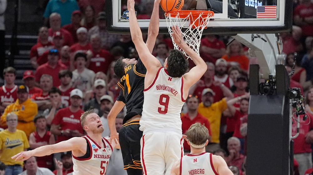 Iowa forward Alvaro Folgueiras (7) dunks over Nebraska forward Berke Buyuktuncel (9) during the second half in the Sweet 16 of the NCAA college basketball tournament Thursday, March 26, 2026, in Houston. (AP Photo/Ashley Landis)
