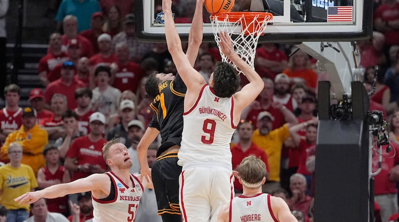 Iowa forward Alvaro Folgueiras (7) dunks over Nebraska forward Berke Buyuktuncel (9) during the second half in the Sweet 16 of the NCAA college basketball tournament Thursday, March 26, 2026, in Houston. (AP Photo/Ashley Landis)
