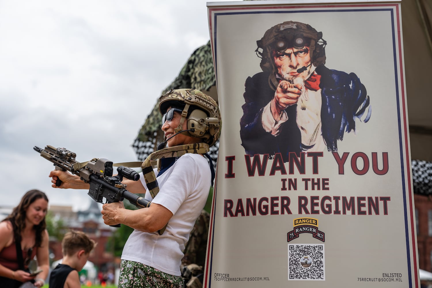 A woman holds a weapon at a ranger tent during the U.S. ArmyÕs 250th anniversary festival on the National Mall in Washington, on Saturday, June 14, 2025. (Eric Lee for The New York Times)