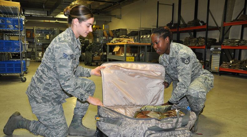 Senior Airman Emily Killingbeck, a unit deployment technician with the 88th Medical Support Squadron, and Staff Sgt. Jeria Dotson, medical readiness training manager, build up a deployment bag at the 88th Medical Readiness Squadron s medical readiness warehouse July 6. (U.S. Air Force photo/Bryan Ripple)