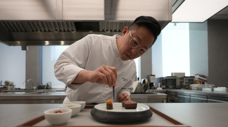 Chef Jun Lee prepares food for a photo at his restaurant SOIGNÉ in Seoul, South Korea, Thursday, Jan. 29, 2026. (AP Photo/Lee Jin-man)