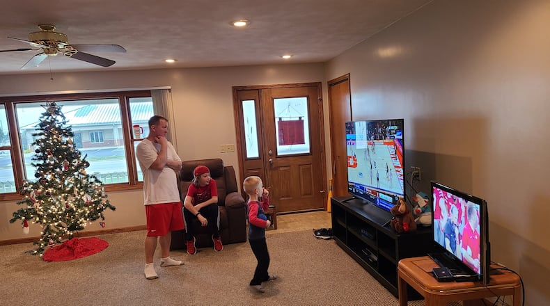 Jay Schwartz, left, and his family watches Dayton play Mississippi State and Ohio State in the Big Ten championship game on Dec. 19, 2020,  in St. Henry.