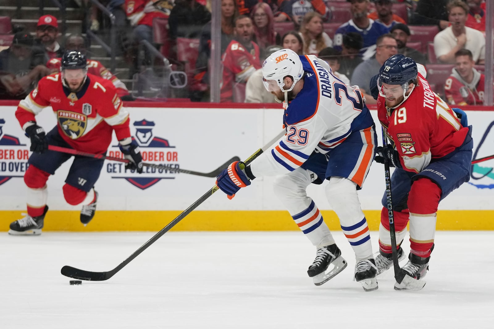 Edmonton Oilers center Leon Draisaitl (29) takes control of the puck as Florida Panthers left wing Matthew Tkachuk (19) defends during the third period of Game 4 of the NHL hockey Stanley Cup Final Thursday, June 12, 2025, in Sunrise, Fla. (AP Photo/Lynne Sladky)