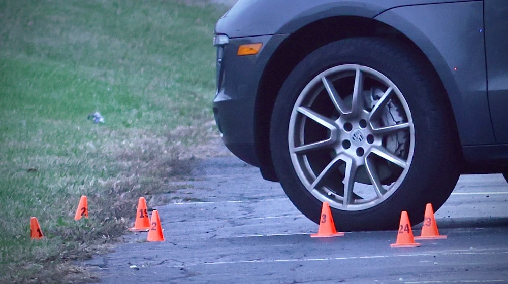 A vehicle with evidence markers near its front wheel after a shooting incident in the Sportsplex parking lot near Dayton Road on Sunday, Nov. 30, 2025 in Fairborn. MARSHALL GORBY / CONTRIBUTED PHOTO