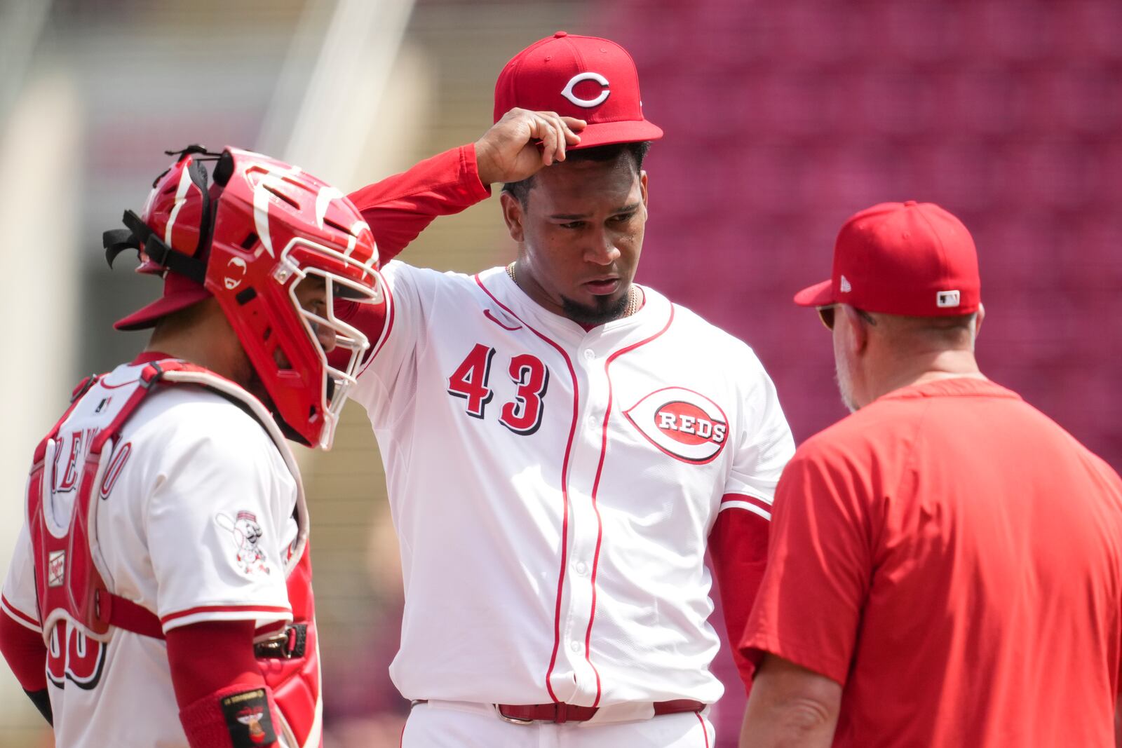 Cincinnati Reds pitcher Alexis Díaz (43) speaks with pitching coach Derek Johnson, right, during the ninth inning of the first baseball game of a doubleheader against the St. Louis Cardinals, Wednesday, April 30, 2025, in Cincinnati. (AP Photo/Jeff Dean)