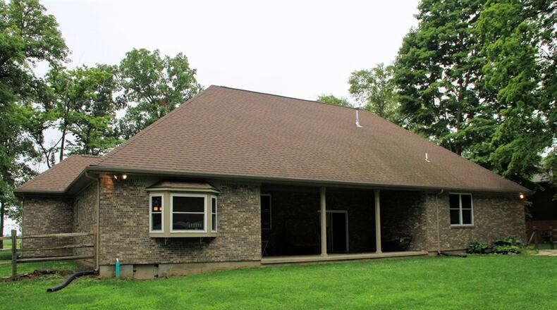 Patio doors off the great room and the breakfast room open to the covered rear porch. The back yard is surrounded by a corral fence and has a man-made waterfalls and koi pond. Some of the acreage is wooded.