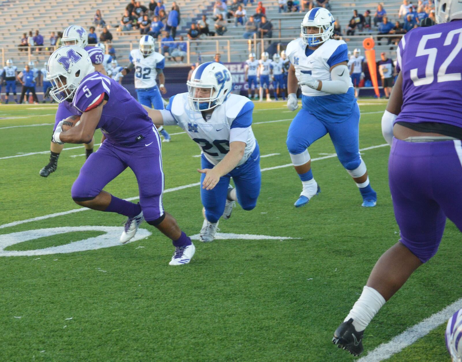 Hamilton’s Elijah Spradling (20) gets a hand on Middletown running back Diondre Cooper (5) during Friday night’s game at Barnitz Stadium in Middletown. CONTRIBUTED PHOTO BY MARITZA MCKINNEY