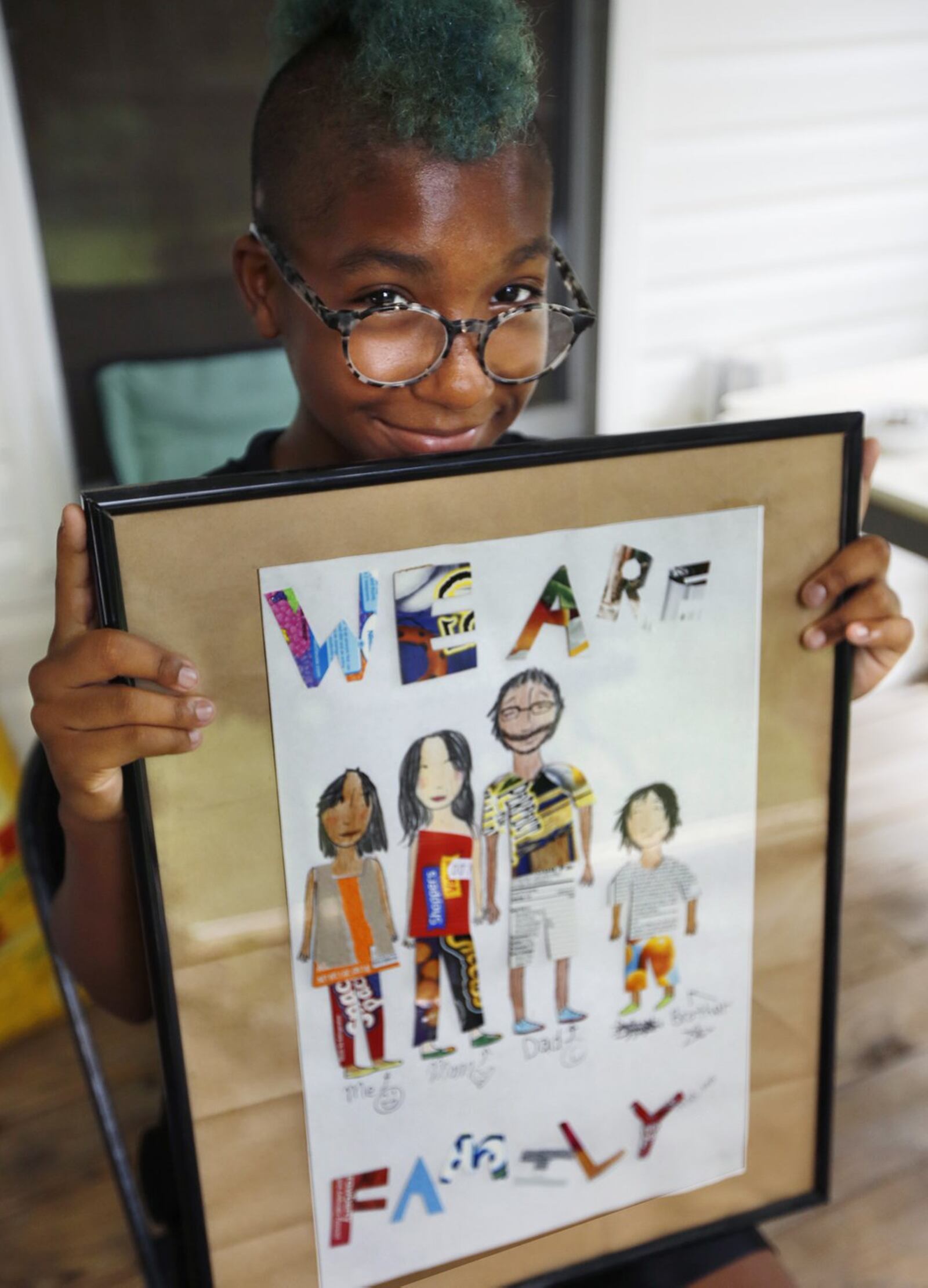 Malaya Booth, 13, who has qualified for two events in the USATF Hershey National Junior Olympics Track and Field Championships in Lawrence, Kansas, July 24-30. She holds a family portrait she created. TY GREENLEES / STAFF