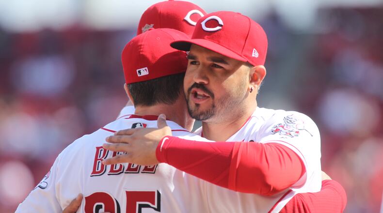 The Reds’ Eugenio Suarez hugs manager David Bell before a game against the Pirates on Opening Day on Thursday, March 28, 2019, at Great American Ball Park in Cincinnati.