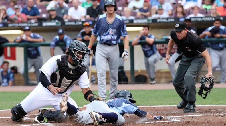 Dayton Dragons catcher Hendrik Clementina tags out West Michigan’s John Valente at the plate at Fifth Third Field on Wednesday. Dayton fell to West Michigan 6-2. CONTRIBUTED PHOTO/MICHAEL COOPER