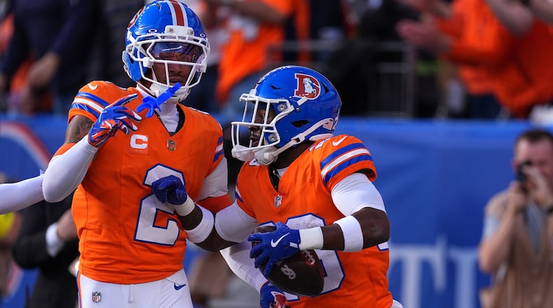 Denver Broncos cornerback Ja'quan McMillian, right, celebrates with cornerback Pat Surtain II (2) after scoring a touchdown on an interception against the Los Angeles Chargers in the first half of an NFL football game Sunday, Jan. 4, 2026, in Denver. (AP Photo/David Zalubowski)