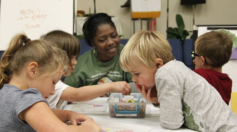 Good Shepherd Academy center manager Eartha DeWalt works with students in a classroom within the Jubilee Community Church in Springboro. TY GREENLEES / STAFF
