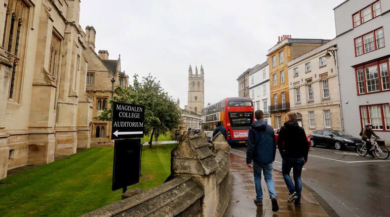 FILE - People walk around Oxford University's campus on Sept. 3, 2017, in Oxford, England. (AP Photo/Caroline Spiezio, File)