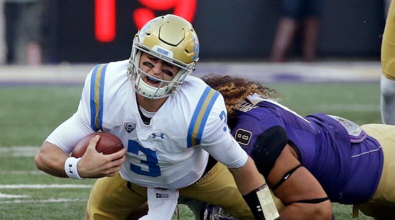 FILE - In this Oct. 28, 2017, file photo, UCLA quarterback Josh Rosen (3) is sacked by Washington's Benning Potoa'e late in the first half of an NCAA college football game, in Seattle. Rosen is being asked to carry a mediocre UCLA team and it seems to be taking a toll. The junior has three touchdown passes and three interceptions in his last three games and has not cracked 60 percent in completions in any of those games. (AP Photo/Elaine Thompson, File)