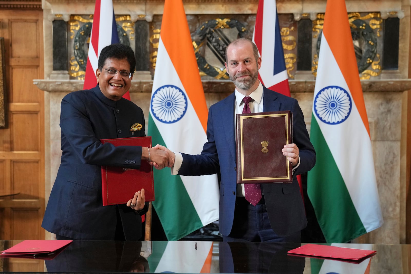 Britain's Secretary of State for Business and Trade, Jonathan Reynolds, right, and Piyush Goyal, Minister of Industry and Supply of India, shake hands after they signed a free trade agreement at Chequers near Aylesbury, England, Thursday, July 24, 2025.(AP Photo/Kin Cheung, Pool)