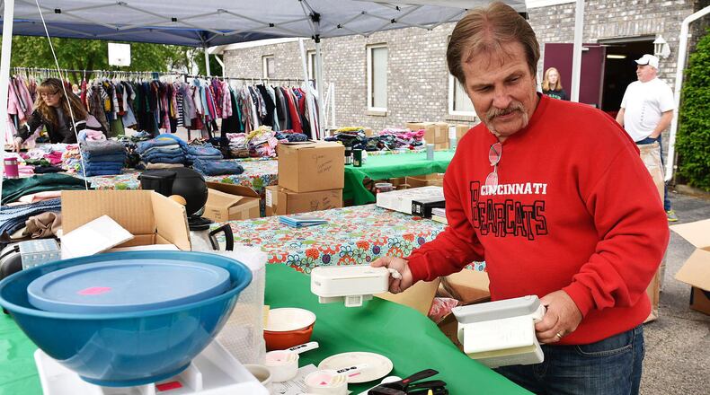 Kurt Schwitalski sets up a booth in the parking lot of the Trenton Moose Lodge for the Trenton Community Yard Sales Friday, May 20 in Trenton. The city-wide garage sales run through Sunday. NICK GRAHAM/STAFF