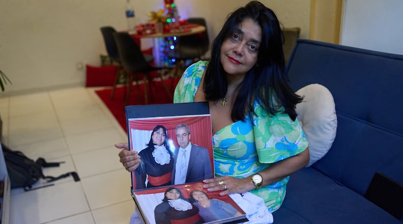 Simone Guimarães holds a photo of herself with her husband, who died from COVID at her home in Sao Goncalo, Rio de Janeiro state, Wednesday, Nov 19, 2025. (AP Photo/Silvia Izquierdo)
