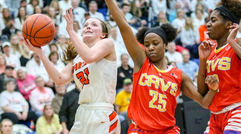 Waynesville High School senior Rachel Murray drives to the hoop against Purcell Marian’s Jaimone Jones (25) and Sha’Dai Hale (32) during a Division III regional final game on Saturday afternoon at Springfield High School. The Spartans won 39-35, advancing to the state tournament for the first time since 2005. CONTRIBUTED PHOTO BY MICHAEL COOPER