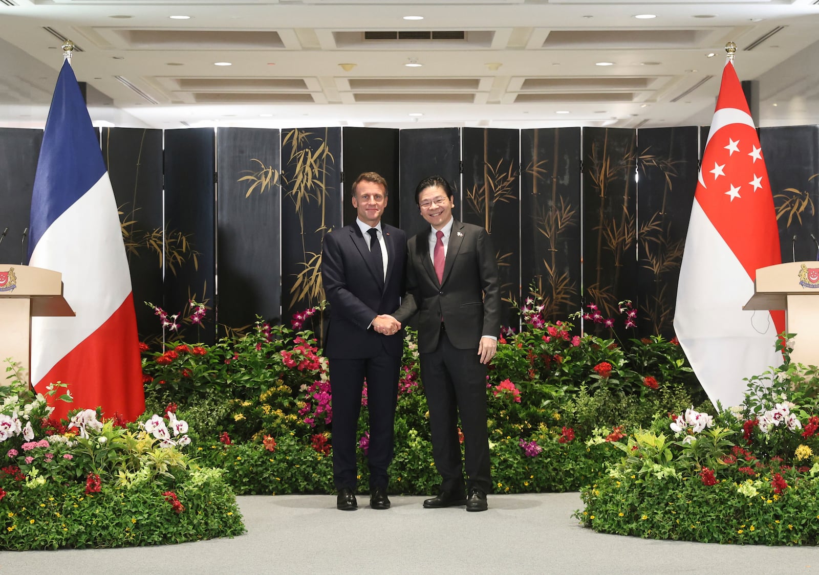 In this photo released by Singapore's Ministry of Digital Development and Information (MDDI), French President Emmanuel Macron, left, shakes hand with Singapore's Prime Minister Lawrence Wong during a joint press conference after ministers from both countries signed multiple bilateral agreements in Singapore, Friday, May 30, 2025.(MDDI via AP)