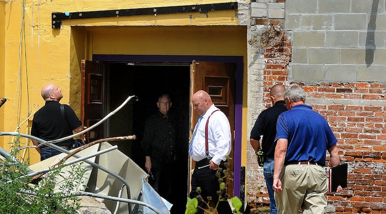 Structural engineer Daniel Geers, of Jezerinac Geers & Associates Inc. (left) examines the 1800s-era Tavern building at 112-118 West Main Street in Troy on Friday, Aug. 18, 2023. Also present were Aaron Lowe (white shirt) of law firm Waite, Tomb, Eberly; Wade Dexter of the Troy Fire Department and assistant Miami County prosecuting attorney Chris Englert (at right); and J. Steven Justice of Dungan & LeFevre law firm (inside building). MARSHALL GORBY\STAFF