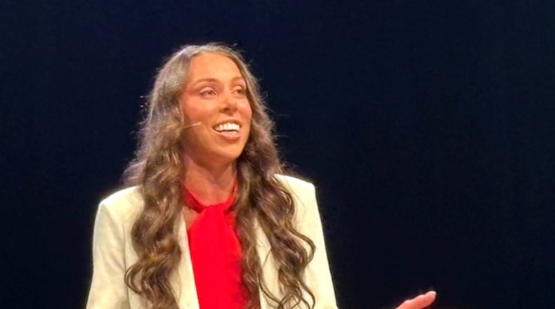 Grace Norman -- the Miami Valley’s most traveled and most decorated athlete of the world stage since Edwin Moses; a winner of four Paralympic Games medals including gold in the triathlon at the 2016 Games in Rio de Janeiro and the 2024 games in Paris, as well as a gold medal winner a six World Championships –- is being honored this week at Cedarville University as the “Young Alumna of the Year.” She’s pictured here speaking to a crowd of over 3,400 CU students at chapel on campus Wednesday; Saturday she’ll ride in the school’s Homecoming Parade. Next week she leaves for the Paratriathlon World Championship in Wollongong, Australia. CONTRIBUTED PHOTO
